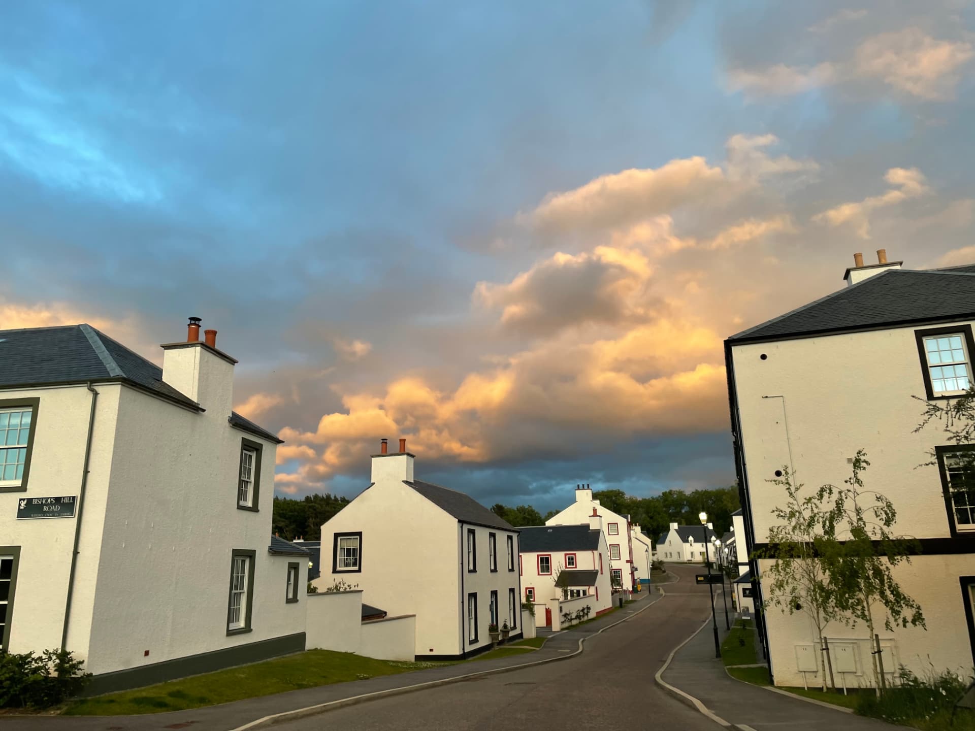 Tornagrain at sunset, white houses lining Bishops Hill Road under golden clouds