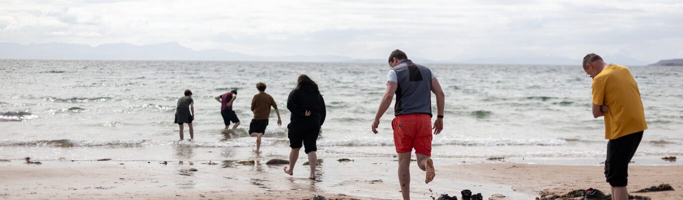 Friends walking together along a wide beach