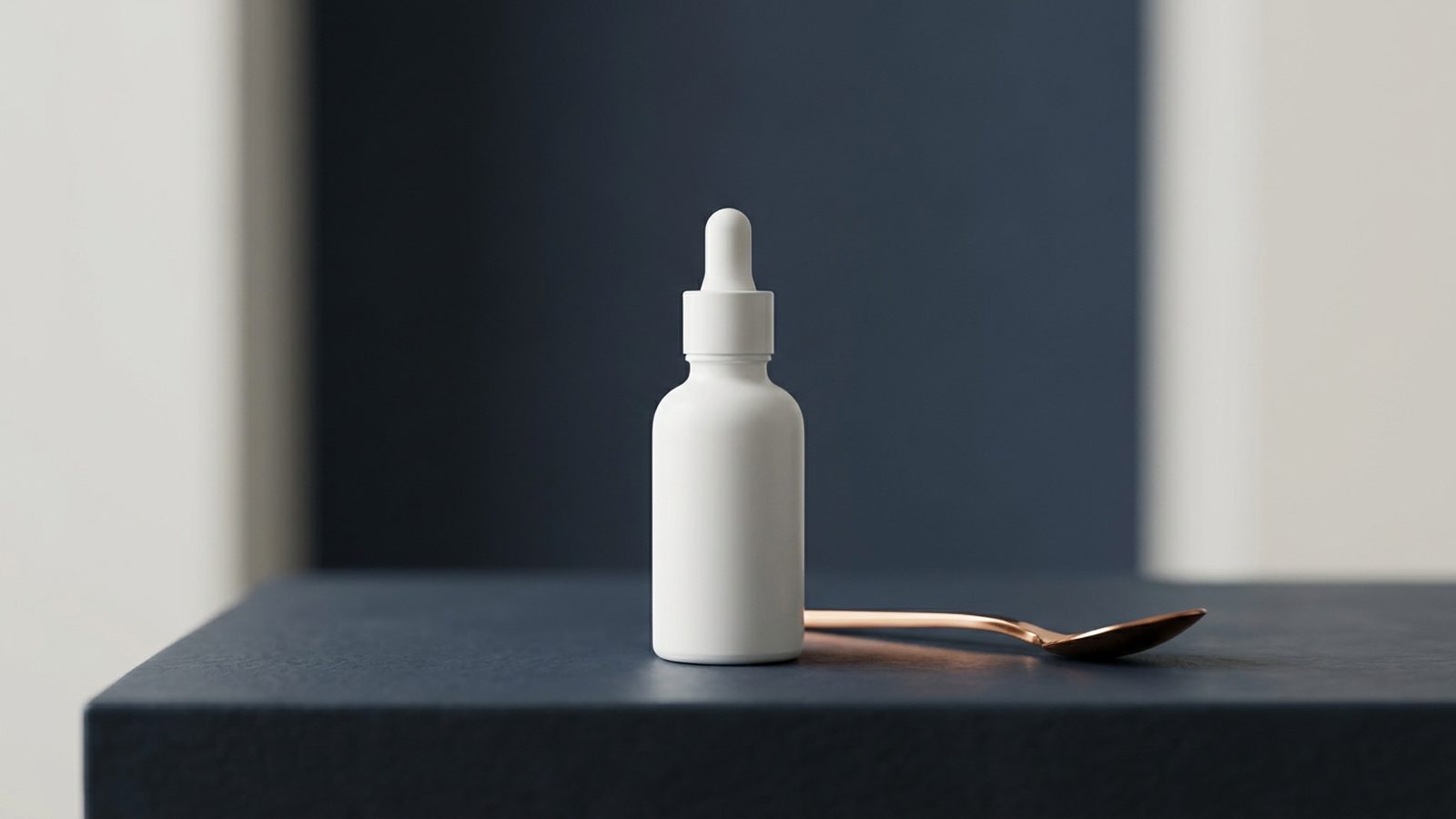 A white ceramic serum bottle stands on a dark stone, looking premium and principled.